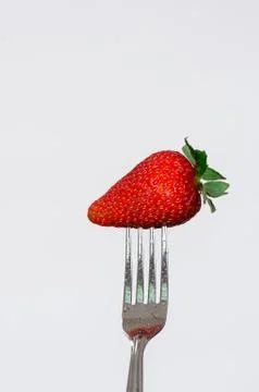 Closeup silver fork with delicious red strawberry and white background Fotos de archivo