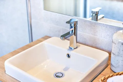 Closeup of a silver taps and ceramic sink Stock Photos