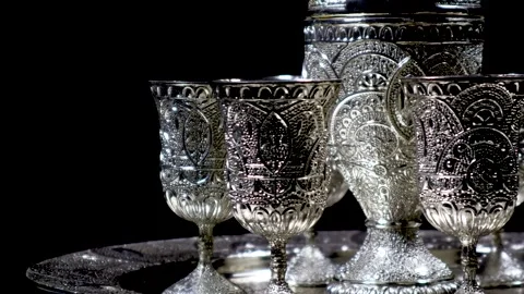 A closeup of a silver ware set, rotating on an automatic display Stock Footage 263042953