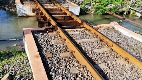 Closeup of Single Railway Track Bridge Crossing Small River with Rusty Texture Stock Footage 332886135