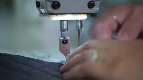 Closeup of skilled artisan quilting under intense lighting conditions 스톡 동영상 321890144