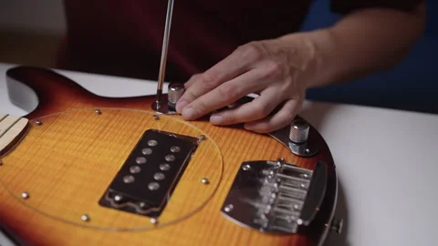 Closeup of skilled luthier hands assembling unique handcrafted electric guitar Stock Footage 348081017