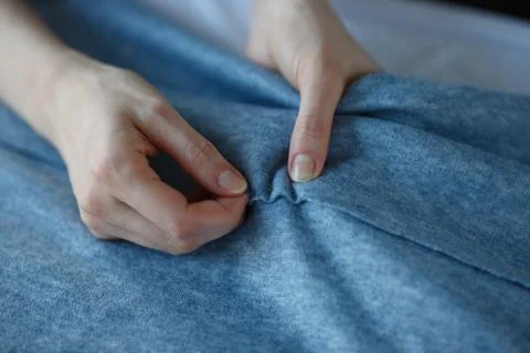 Closeup of skilled tailor hands marking and measuring fabric while making Stock Photos