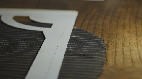 Closeup of skilled tailor working in atelier: hands marking and measuring fabric Stock Footage 127287220