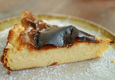 Closeup a Slice of Delectable Homemade Basque Burnt Cheesecake on Clayware Plate 스톡 사진