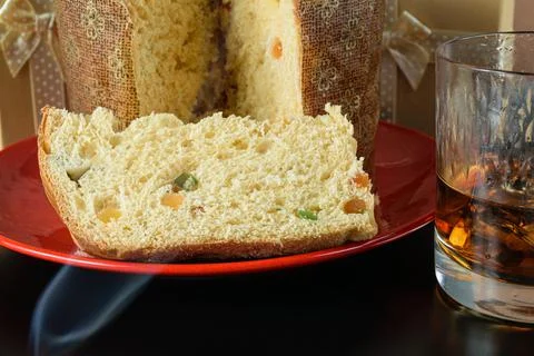 Closeup of a slice of panettone under cigarette smoke, next to a glass of whi Stock Photos