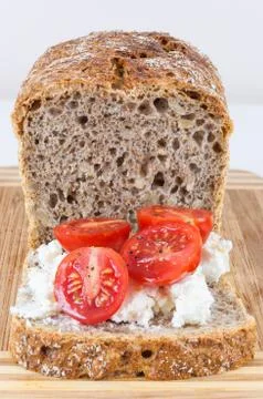 Closeup of slice of wholemeal bread with cottage cheese and cherry tomatoes Stock Photos