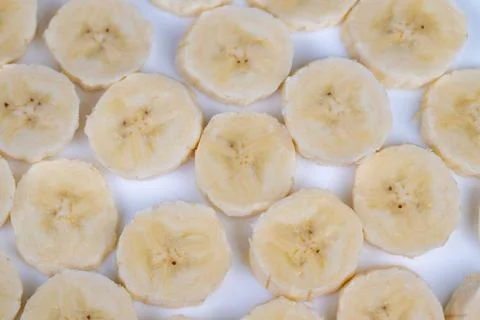 Closeup sliced bananas in pattern. Soft lighting, clean white background, rep Stock Photos