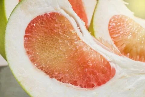 Closeup, sliced ​​red pomelo fruit, on the table Stock Photos