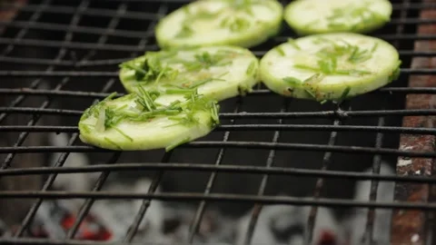 Closeup sliced vegetable marrow are being cooked on the bbq grill during the day Stock Footage 213996296