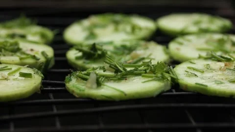 Closeup sliced vegetable marrow are being cooked on the bbq grill during the day Stock Footage 213996588