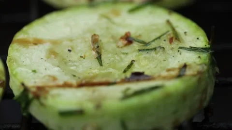 Closeup sliced vegetable marrow are being cooked on the bbq grill during the day Stock Footage 213996693