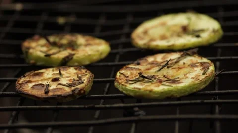 Closeup sliced vegetable marrow are being cooked on the bbq grill during the day Stock Footage 213997470