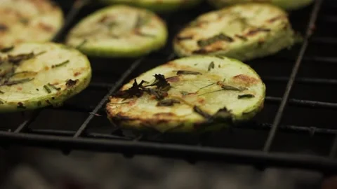 Closeup sliced vegetable marrow are being cooked on the bbq grill during the day Stock Footage 213997533