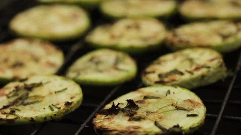 Closeup sliced vegetable marrow are being cooked on the bbq grill during the day Stock Footage 213997780