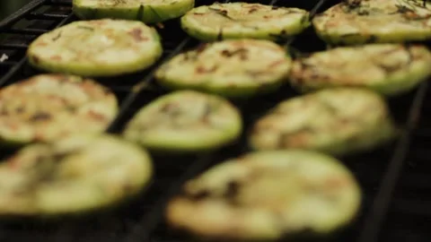 Closeup sliced vegetable marrow are being cooked on the bbq grill during the day Stock Footage 213997798
