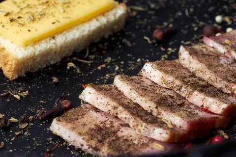 Closeup slices of breast and a cheese sandwich with spices. Stock Photos