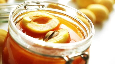 CLOSEUP: Slices of fresh apricot fall into a jar Stock Footage 40220935