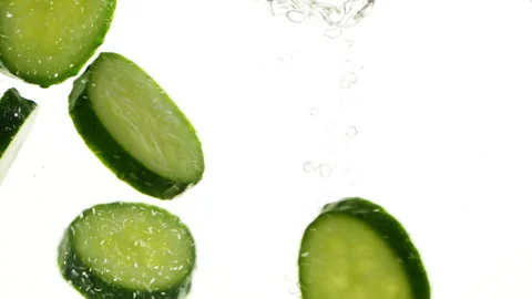 Closeup slices of fresh green cucumbers in water, vegetables on white background 스톡 동영상 273016828