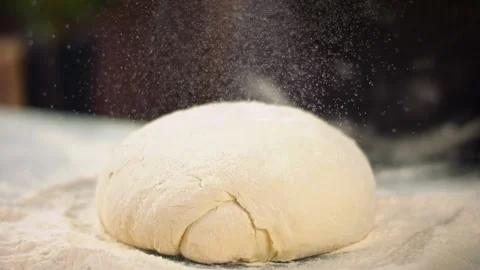 Closeup slow mo shot of hands of chef applying flour on dough Stock Footage 137318629