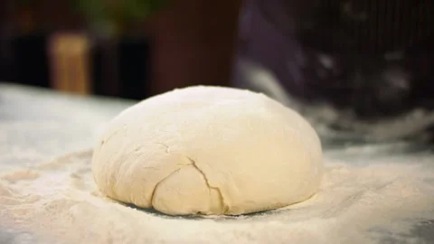 Closeup slow mo shot of hands of chef applying flour on dough Stock Footage 137318846