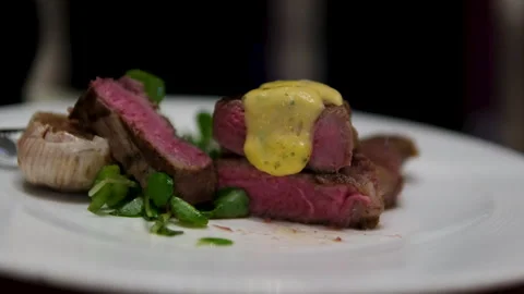Closeup slow-motion of adding sauce next to Ossobuco cooked veal shank steak on Video stock 302110666