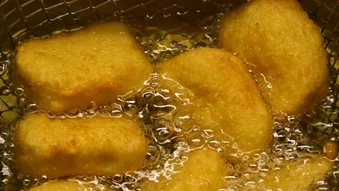 Closeup slow motion crispy fried chicken meat nuggets deep frying in boiling oil Stock Footage 291372041