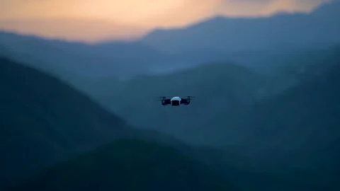 Closeup slow motion of flying drone at sunset sky in mountains. Video stock 158174876