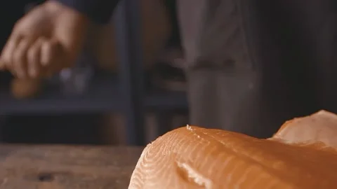 Closeup slow motion of piece of fresh salmon sprinkled with salt flakes during Stock Footage 154674522