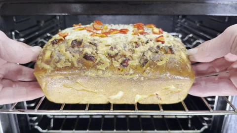 Closeup slow motion shot of hands removing from an oven a loaf of bread. Stock Footage 303441305