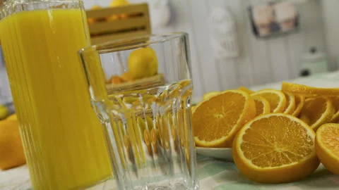 Closeup, slow motion shot of juice being poured into glass near orange slices Stock Footage 341258249