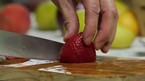 Closeup, slow motion shot of knife slicing through strawberry Stock Footage 341239601