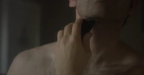 Closeup slow motion shot of a man using an electric beard trimmer Stock Footage 64032855