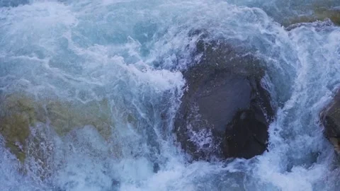 Closeup slow motion shot of a rock obstructing the flow of the river Parvati Stock-Footage 200402010
