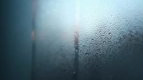 Closeup slow motion video of water drops on glass window. Abstract blue bubbles Stock Footage 325104021