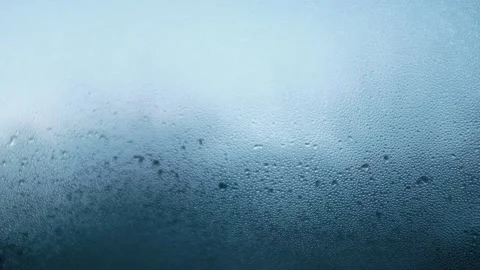 Closeup slow motion video of water drops on glass window. Abstract blue bubbles. Stock Footage 325104104