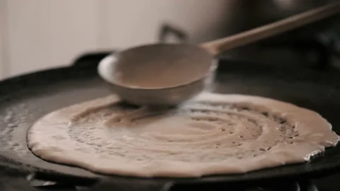 Closeup slow motion view of  steaming hot 'Dosa' on a cast iron pan Stock Footage 130836478
