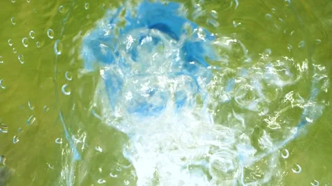 Closeup slow motion water falling down from bottle with drops splashing on grass 库存影片 157998472