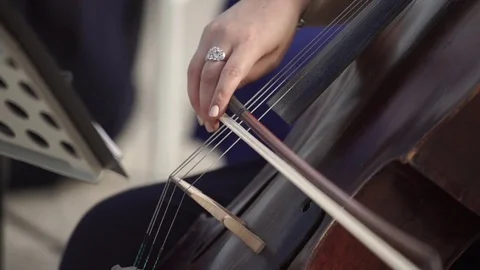Closeup slowmotion shot of a girl musician playing the cello Stock Footage