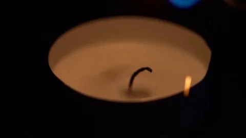 Closeup of a small candle lighting up in the darkness slow motion Stock Footage 76193899