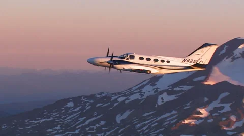 CLOSEUP SMALL PLANE FLYING OVER SNOWY MOUNTAINS Stock Footage 52554141