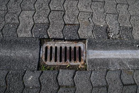 Closeup of a small rectangular manhole for rain water drainage with pattern of Stock Photos