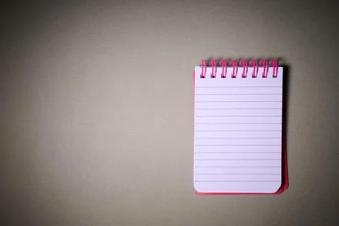 Closeup of a small spiral notebook open on a desk. Stock Photos