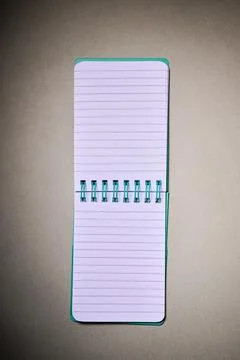 Closeup of a small spiral notebook open on a desk. Stock Photos