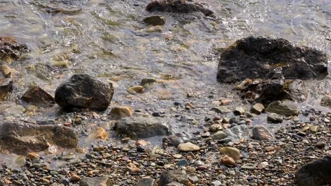 Closeup of small wave tide pools on a rocky beach Stock Footage 106480473