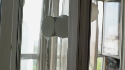 Closeup of smart robot window cleaner washing glass with round rags inside Stock Footage 251211213