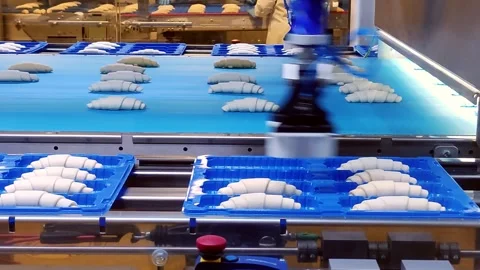 Closeup. A smart robotic arm places croissants on a baking sheet. Smart robotic Stock Footage 245224363