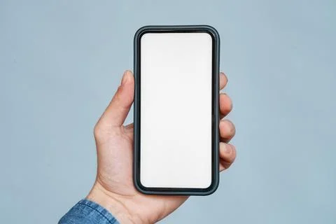Closeup smartphone blank white screen mockup in hand over blue copy space Foto stock