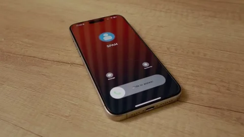 Closeup of smartphone receiving spam call on wooden table 스톡 동영상 334043869