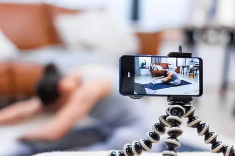 Closeup smartphone screen, process of live video recording. Young woman is sh Stock Photos